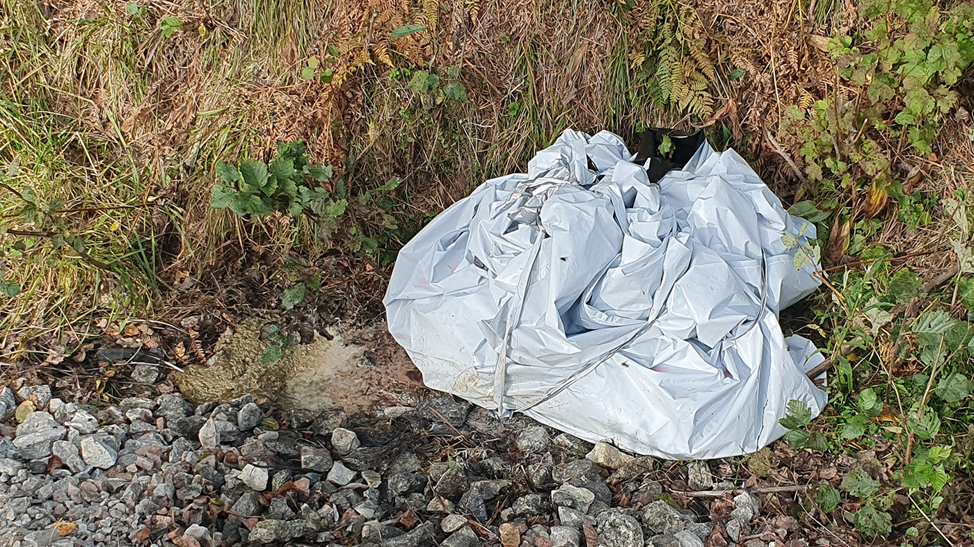 Stort plastpaket i dike.