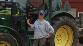 SVA:s medarbetare Linda Engblom som står framför en traktor.