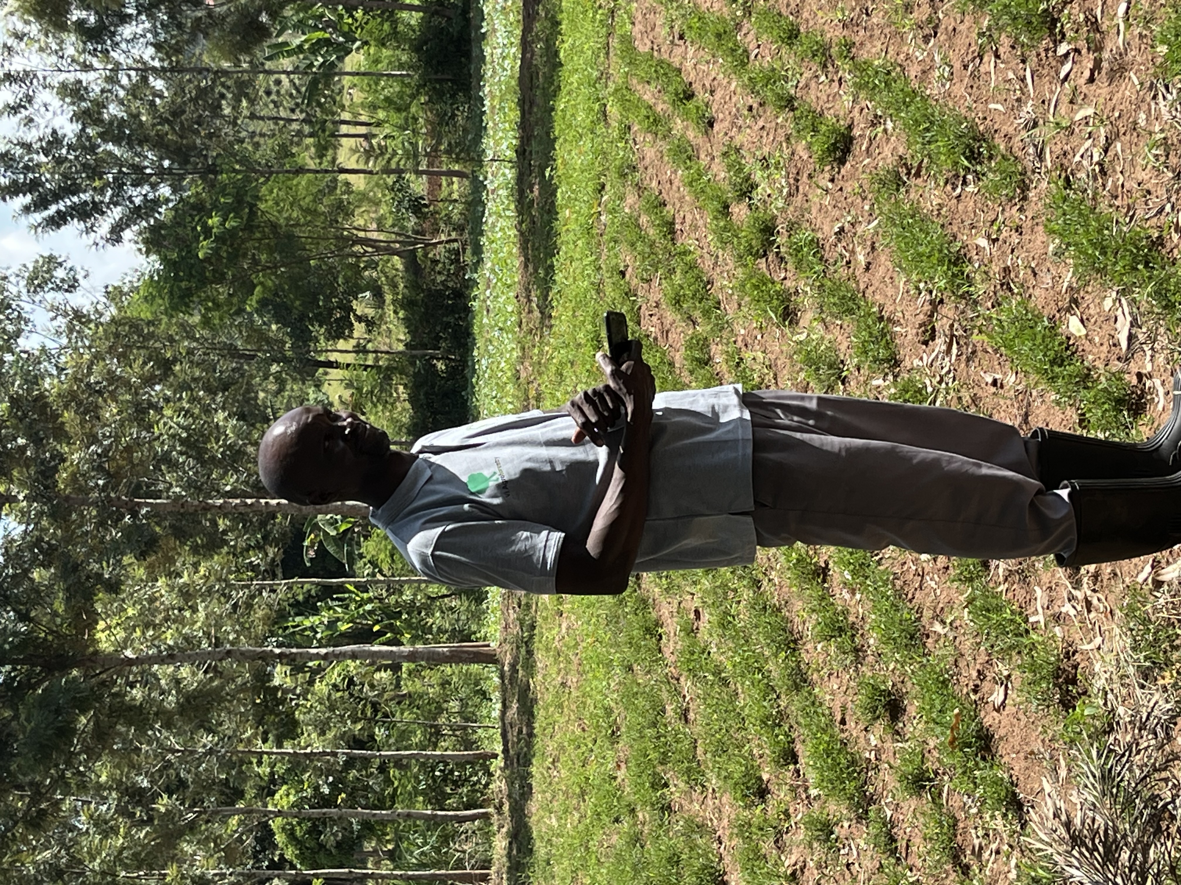 Småbrukare med mobil vid en åker.