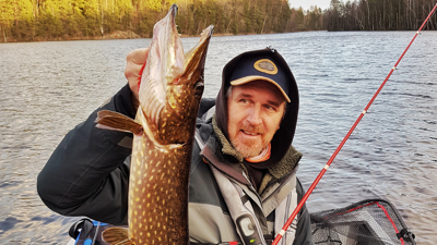 Fiskeguiden Johan Skoglund med en gädda fångad i en insjö.